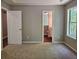 This cozy bedroom features neutral walls, plush carpet, and a bright window, creating a calming retreat at 14 Highland Dr, Carrollton, GA 30116