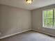 Bright bedroom featuring plush carpet, a window with green views, and neutral walls at 14 Highland Dr, Carrollton, GA 30116