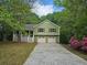 Charming home featuring a front porch, two-car garage, and a well-maintained front yard surrounded by mature trees at 14 Highland Dr, Carrollton, GA 30116