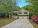 Charming home featuring a front porch, two-car garage, and a well-maintained front yard surrounded by mature trees at 14 Highland Dr, Carrollton, GA 30116