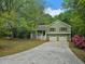 Charming home featuring a front porch, two-car garage, and a well-maintained front yard surrounded by mature trees at 14 Highland Dr, Carrollton, GA 30116