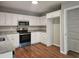 Modern kitchen featuring white cabinets, granite countertops, stainless steel appliances, and hardwood floors at 14 Highland Dr, Carrollton, GA 30116