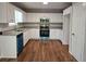 Modern kitchen featuring white cabinets, granite countertops, stainless steel appliances, and hardwood floors at 14 Highland Dr, Carrollton, GA 30116