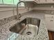 Close up of a stainless steel kitchen sink with granite countertops and white cabinets at 14 Highland Dr, Carrollton, GA 30116