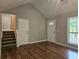Open living room featuring wood floors, vaulted ceiling, and access to the staircase at 14 Highland Dr, Carrollton, GA 30116
