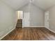 Open living room featuring wood floors, vaulted ceiling, and access to the staircase at 14 Highland Dr, Carrollton, GA 30116