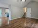 Open living room featuring wood floors, vaulted ceiling, and access to the kitchen and staircase at 14 Highland Dr, Carrollton, GA 30116