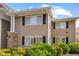 Tan two-story condo with black shutters and well-manicured landscaping at 1468 Briarwood Ne Rd # 602, Atlanta, GA 30319