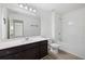 Full bathroom featuring a large mirror, vanity, shower-tub combo, and sleek hardwood flooring at 4655 Bluffton Ct, Cumming, GA 30028