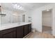 Bathroom with dark cabinets, large mirror, and wood-style flooring with a view to the closet at 4655 Bluffton Ct, Cumming, GA 30028