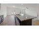 Open-concept kitchen with a central island, dark cabinets, granite countertops, and stainless steel appliances at 4655 Bluffton Ct, Cumming, GA 30028