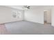 Spacious carpeted living room with a ceiling fan, bright windows, and access to the bathroom at 4655 Bluffton Ct, Cumming, GA 30028