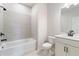 Bathroom featuring neutral tiles, shower-tub combo, and modern vanity with black hardware at 7515 Woolf Way, Cumming, GA 30028