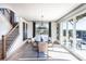 Elegant dining area with outdoor access, a modern light fixture, and the home's staircase at 7515 Woolf Way, Cumming, GA 30028