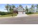 Beautiful two-story home with a manicured lawn, covered porch, and a three-car garage at 7515 Woolf Way, Cumming, GA 30028