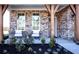 Inviting front porch with brick columns and cozy seating with landscaped garden at 7515 Woolf Way, Cumming, GA 30028