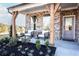 Charming front porch with brick, wooden pillars, and seating for relaxing in the landscaped front yard at 7515 Woolf Way, Cumming, GA 30028
