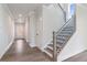 Inviting hallway with hardwood floors, a staircase with black metal railings, and recessed lighting at 7515 Woolf Way, Cumming, GA 30028