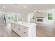 An open-concept kitchen shows an island, access to a patio, and a modern fireplace at 7515 Woolf Way, Cumming, GA 30028