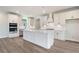 An open kitchen showcases white cabinets, an island with white countertop, and stainless steel appliances at 7515 Woolf Way, Cumming, GA 30028