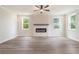 Bright living room featuring a modern fireplace, hardwood floors, and large windows at 7515 Woolf Way, Cumming, GA 30028