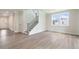 Spacious living room with hardwood floors, staircase, and large windows that provide natural light at 7515 Woolf Way, Cumming, GA 30028