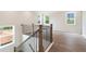 Staircase with modern metal balusters, wooden handrail, with natural light from large windows at 7515 Woolf Way, Cumming, GA 30028