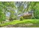 Spacious backyard featuring a lush lawn, mature trees, and a large deck, offering privacy and relaxation at 1872 Lake Lucerne Sw Dr, Lilburn, GA 30047
