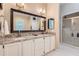 Bathroom featuring a double vanity with granite countertops, framed mirror and a glass shower enclosure at 1872 Lake Lucerne Sw Dr, Lilburn, GA 30047