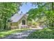 Charming home nestled in mature trees boasts a beautifully landscaped yard and inviting driveway at 1872 Lake Lucerne Sw Dr, Lilburn, GA 30047