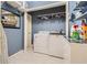 Well-organized laundry room with washer, dryer, storage shelves, and a tiled counter, perfect for household chores at 1872 Lake Lucerne Sw Dr, Lilburn, GA 30047