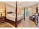 Elegant bedroom featuring a four-poster bed, hardwood floors, and access to a private outdoor deck at 1872 Lake Lucerne Sw Dr, Lilburn, GA 30047
