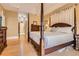 Bedroom featuring a four-poster bed, hardwood floors, neutral paint and a view into the hallway at 1872 Lake Lucerne Sw Dr, Lilburn, GA 30047