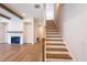 Bright staircase with wood steps, white risers, and a fireplace nearby at 5235 Memento Trace, Cumming, GA 30040