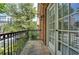 A relaxing balcony with an iron railing and an exterior light with green trees in the background at 774 Piedmont Ne Ave # 11B, Atlanta, GA 30308