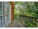 Relaxing balcony with an iron railing and an exterior light with a beautiful lush green tree background at 774 Piedmont Ne Ave # 11B, Atlanta, GA 30308