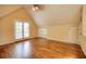 Spacious empty bedroom featuring hardwood floors, doors to an exterior balcony, and sloped ceilings at 774 Piedmont Ne Ave # 11B, Atlanta, GA 30308