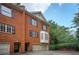 Elegant brick townhome featuring an attached garage, black shutters, and lush greenery at 774 Piedmont Ne Ave # 11B, Atlanta, GA 30308