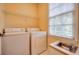 Bright laundry room with washer, dryer, sink, storage shelf, and natural light at 774 Piedmont Ne Ave # 11B, Atlanta, GA 30308