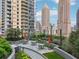 Landscaped courtyard featuring seating areas, greenery, and a walking path among high-rise buildings at 1080 Peachtree Ne St # 2416, Atlanta, GA 30309