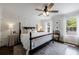 Bright bedroom with paneled accent wall, four-poster bed, hardwood floors and plenty of natural light at 12 Valley Forge Nw Pl # 215, Atlanta, GA 30318