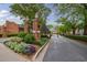 A charming entrance featuring brick pillars, mature trees, and lush landscaping that welcomes you to the community at 12 Valley Forge Nw Pl # 215, Atlanta, GA 30318