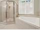 Bathroom features a glass-enclosed shower and a separate soaking tub under a bright window at 222 Rippling Nw Dr, Marietta, GA 30064