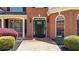 Close-up of a home's elegant entrance, featuring a black door with sidelights and manicured shrubs at 222 Rippling Nw Dr, Marietta, GA 30064