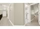 Upstairs hallway with neutral colored walls and carpeted floors leading to a bathroom and an attic access door at 222 Rippling Nw Dr, Marietta, GA 30064