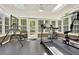 Bright sun room filled with exercise equipment, surrounded by windows offering scenic backyard views at 222 Rippling Nw Dr, Marietta, GA 30064