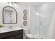 Elegant bathroom featuring a dark vanity and framed glass shower with white subway tile surround at 5345 Keepsake Court, Cumming, GA 30040