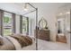 Light bedroom featuring a four-poster bed, dresser with round mirror, and bright windows at 5345 Keepsake Court, Cumming, GA 30040