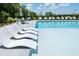 Community swimming pool with white lounge chairs and tables with chairs and umbrellas at 5345 Keepsake Court, Cumming, GA 30040