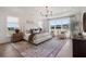 Spacious main bedroom features a tray ceiling, large windows, seating area, and elegant decor at 5345 Keepsake Court, Cumming, GA 30040